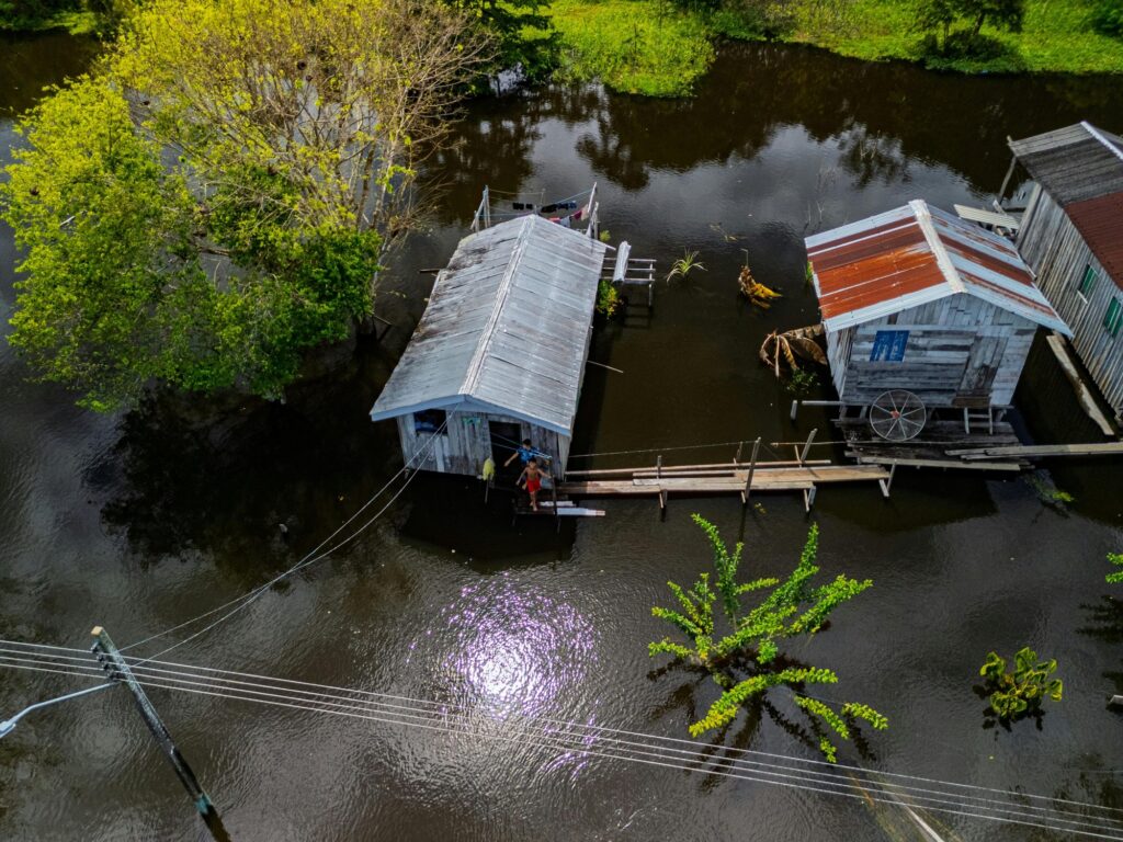 Aerial view of two flooded houses in Amazonia